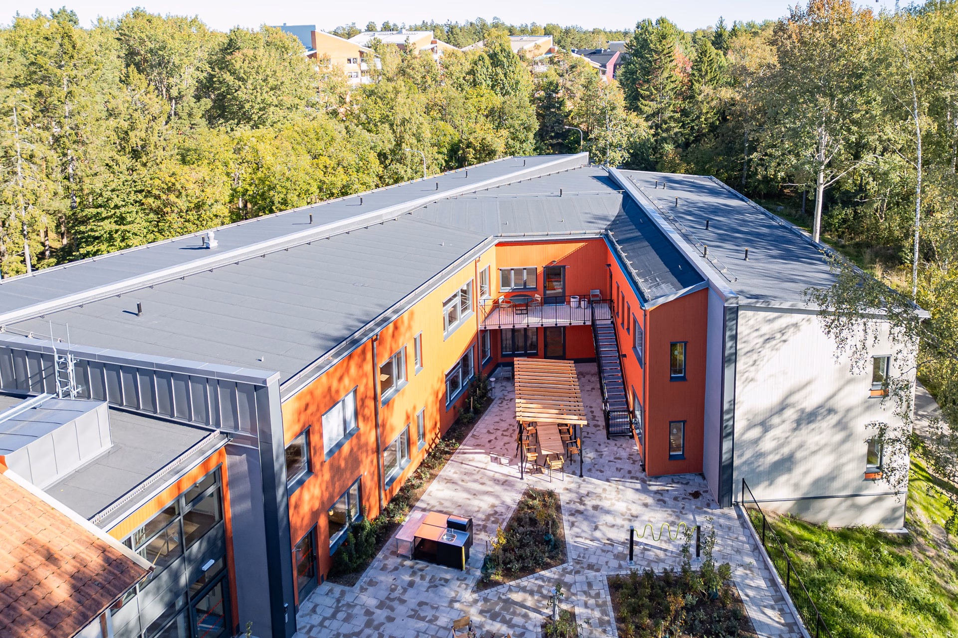 En flygbild av en byggnad intill en skog.