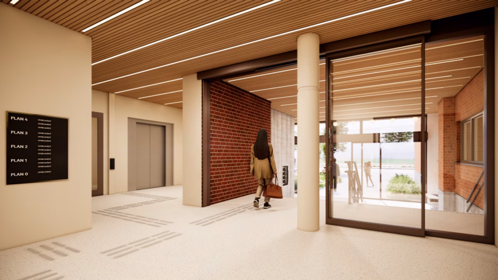 En kvinna med en resväska går ut från en byggnad.